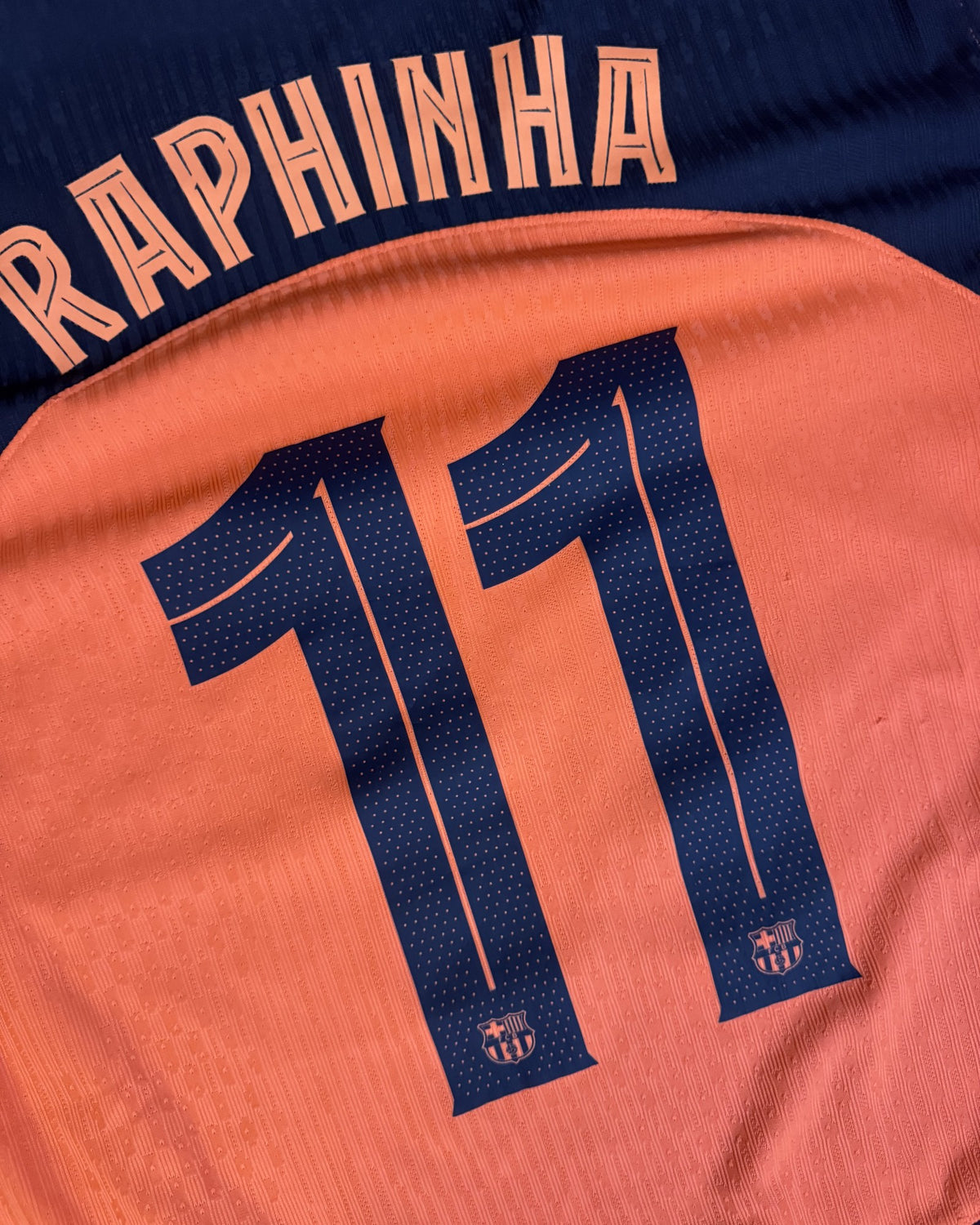 Close-up of the Raphinha 11 name and number on the player version fabric
